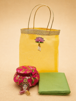 Yellow organza bag matki hamper with cotton blouse piece and Lakshmi haldi kumkum set for Varalakshmi Vratham return gifts.