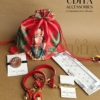 Half Saree ceremony return gift hamper with designer potli bag, silk thread bangles, bracelet, floral hair accessory, and bindi packet.