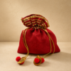 Premium red silk potli bag with decorative pleated golden border, drawstring closure, and pom-pom tassels for weddings, return gifts, festive gifting, pooja ceremonies, and jewellery packaging.