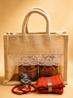 Window jute hamper baby shower return gift set with Krishna Haldi Kumkum, silk thread bangles, and brocade blouse piece.