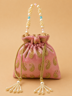 Premium pink designer potli bag with golden paisley embroidery, pearl handle, crystal bead accents, and pearl tassel drawstrings, ideal for weddings, bridal gifting, festive occasions, and return gifts.