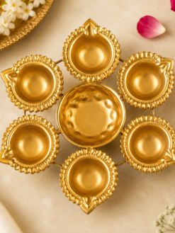 Traditional metal urli bowl with six decorative diyas in a gold finish for pooja, Diwali decor, housewarming gifts, and festive celebrations.