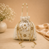 Off white pearl embroidered potli bag with pearl handle and tassel drawstrings, designer return gift pouch for weddings, bridal gifting, festivals, and special occasions.