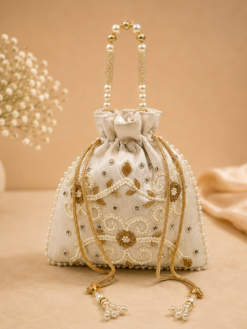 Off white pearl embroidered potli bag with pearl handle and tassel drawstrings, designer return gift pouch for weddings, bridal gifting, festivals, and special occasions.