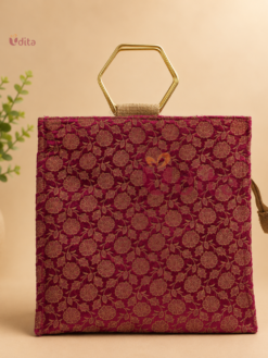 Premium floral jute bag with elegant gold metal handles, eco-friendly reusable return gift bag available in assorted colours and floral brocade designs for weddings, festivals, housewarming, and corporate gifting.