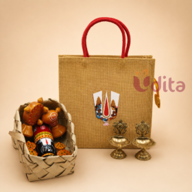 Housewarming return gift hamper with Namam jute bag, Kondapalli Balaji doll, and brass Shanku Chakra diyas.