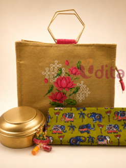 Traditional return gift hamper with lotus jute bag, brass storage container, cotton blouse piece, Haldi Kumkum, and Lakshmi idol for weddings and housewarming.