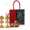 Kalamkari jute bag return gift hamper with brass diyas, cotton blouse piece and Haldi Kumkum for housewarming ceremonies.